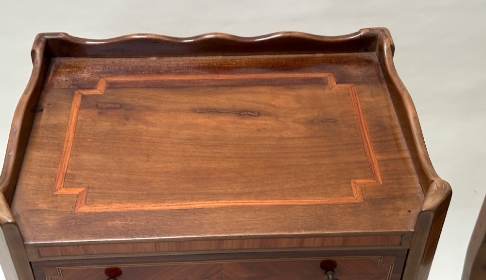 A pair of French Louis XV style warm brown walnut bedside tables featuring geometric parquetry inlay, shaped galleries, and slender cabriole legs. View III