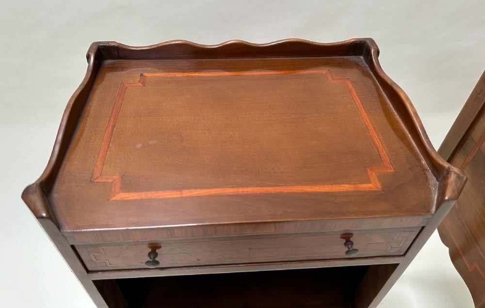 A pair of French Louis XV style warm brown walnut bedside tables featuring geometric parquetry inlay, shaped galleries, and slender cabriole legs. View IX