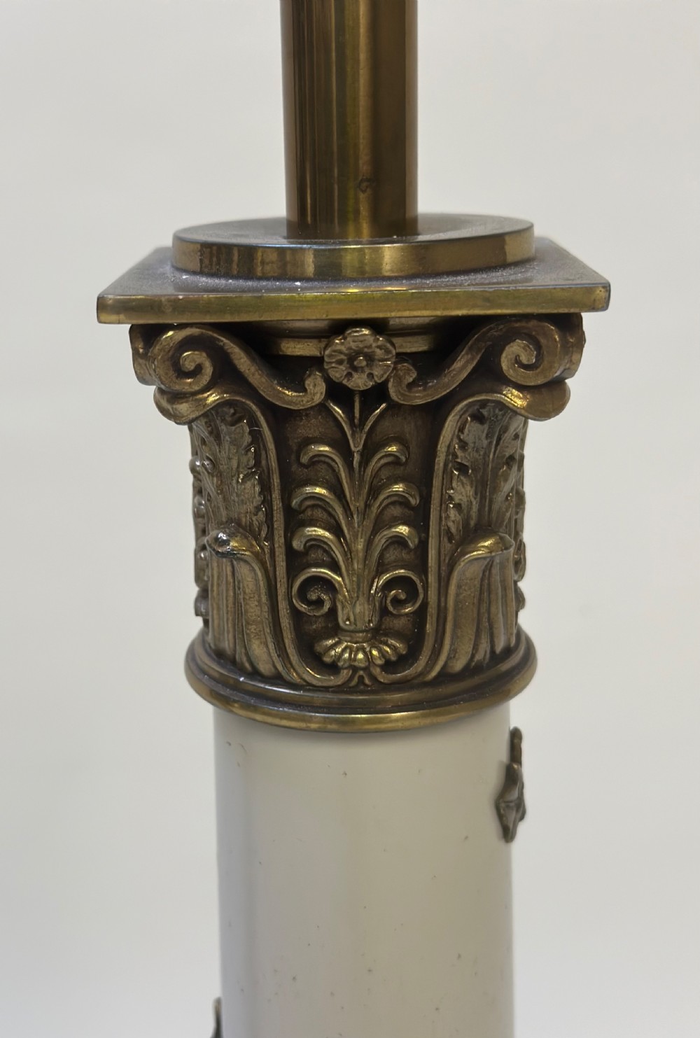 A pair of tall Neoclassical table lamps featuring cream shafts with brass garland detail and brass Corinthian capitals on stepped bases. View III