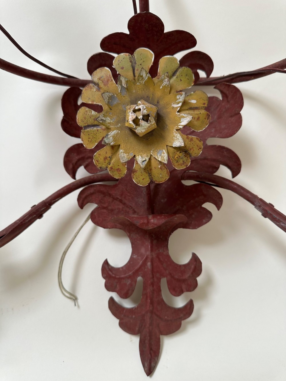 A pair of large French wrought iron five-light wall sconces finished in dark red paint with central gilt floral rosettes and sweeping scrolling arms. View III