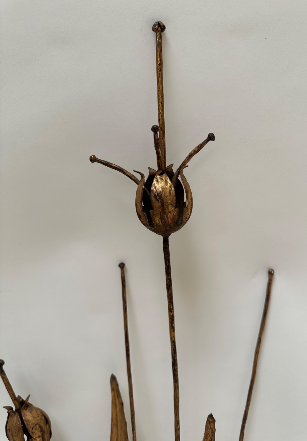 A pair of gold-gilded metal wall sconces featuring slender botanical stems with seed pods and twin scrolling candle arms. View IV