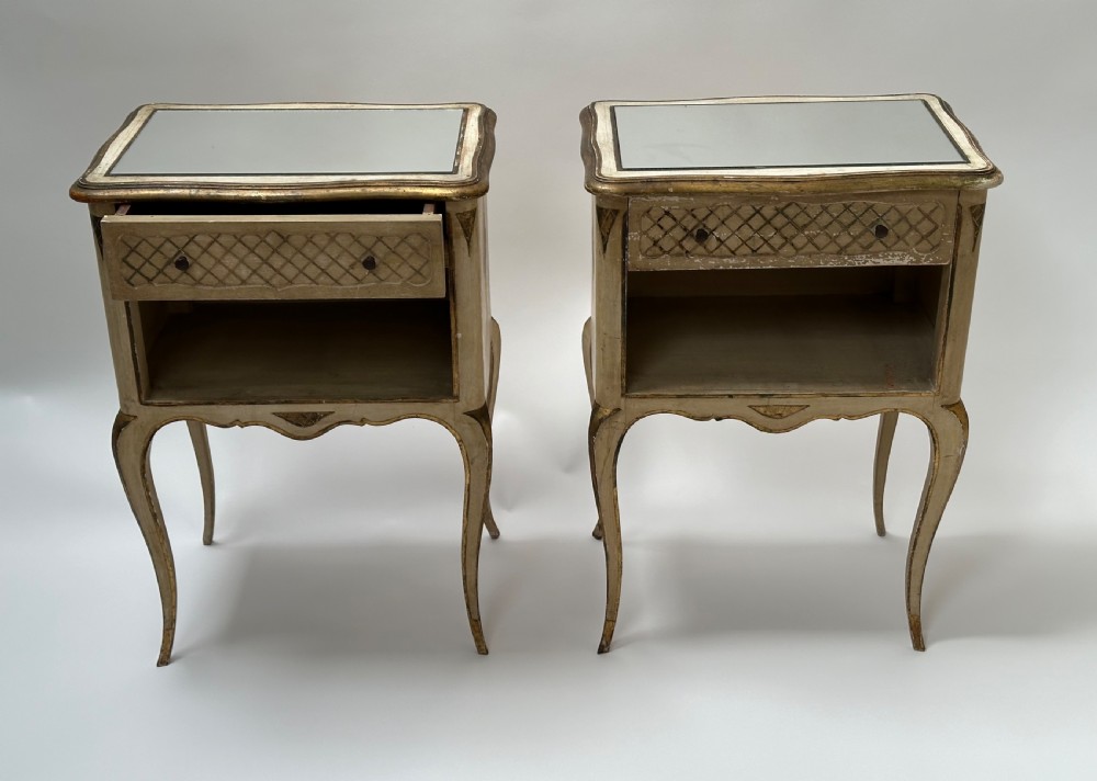 A pair of cream and gold Florentine bedside tables featuring mirrored tops, open lower compartments, carved lattice drawers, and slender cabriole legs. View II
