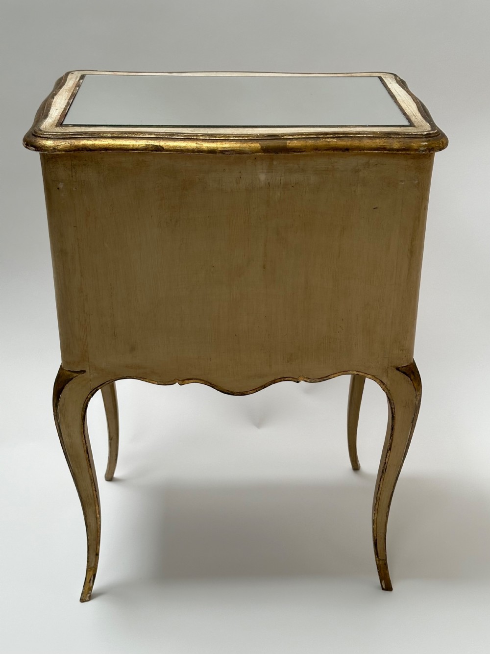 A pair of cream and gold Florentine bedside tables featuring mirrored tops, open lower compartments, carved lattice drawers, and slender cabriole legs. View VIII