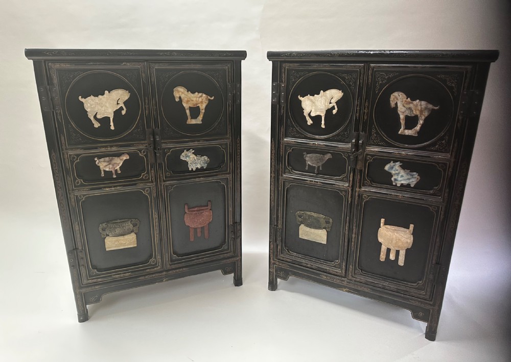 A pair of black lacquered two-door Chinoiserie cabinets featuring carved hardstone inlays of horses, animals, and vessels, topped with gilt scrollwork motifs. View IV