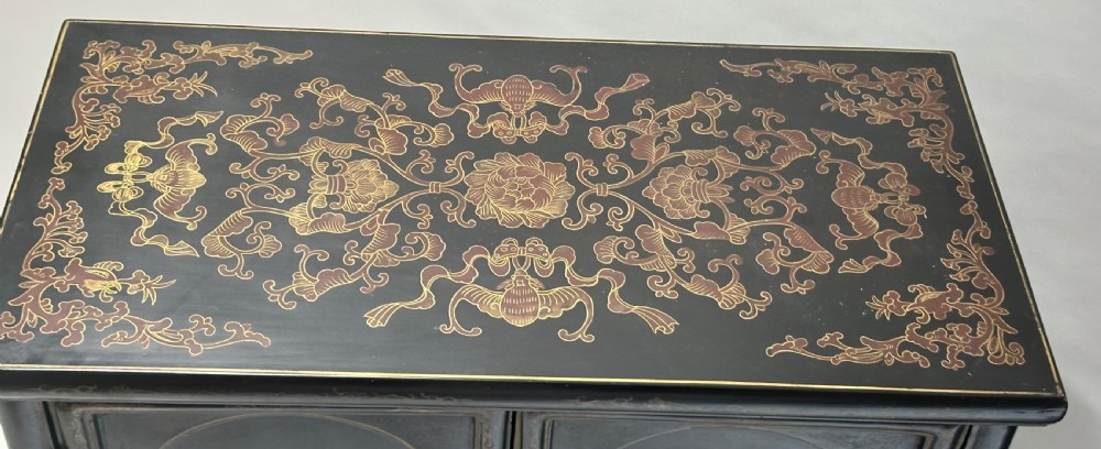 A pair of black lacquered two-door Chinoiserie cabinets featuring carved hardstone inlays of horses, animals, and vessels, topped with gilt scrollwork motifs. View XII