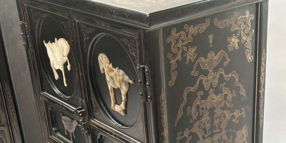 A pair of black lacquered two-door Chinoiserie cabinets featuring carved hardstone inlays of horses, animals, and vessels, topped with gilt scrollwork motifs. View XIII