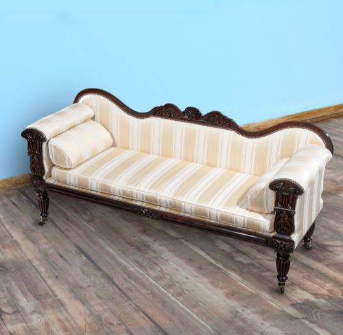 fig 1. A matching pair of 19th-century dark rosewood sofas with carved cresting, scroll arms, reeded legs on brass castors, and cream striped fabric upholstery.