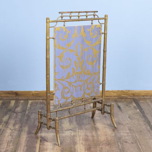 fig 1. A Regency faux bamboo brass fire screen with an upholstered purple panel displaying gold acanthus leaf scrollwork.