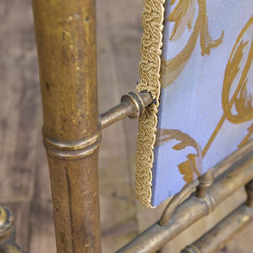 A Regency faux bamboo brass fire screen with an upholstered purple panel displaying gold acanthus leaf scrollwork. View IX