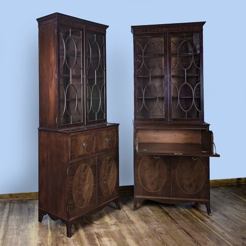 fig 5. A pair of tall George III mahogany bookcases featuring oval astragal glazed upper doors above deep drawers and flame mahogany panelled cupboard bases.