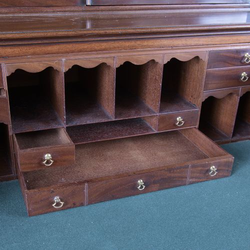 A pair of tall George III mahogany bookcases featuring oval astragal glazed upper doors above deep drawers and flame mahogany panelled cupboard bases. View XV
