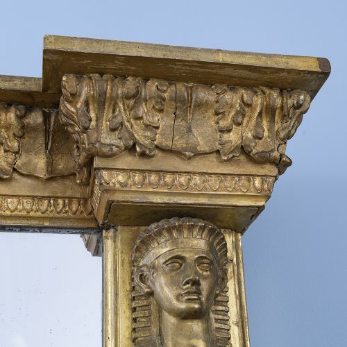 fig 1. A rectangular Regency giltwood overmantel mirror framed with Egyptian revival term pilasters, sculpted head capitals, and an architectural molded cornice.