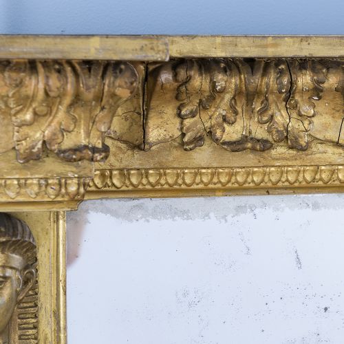 A rectangular Regency giltwood overmantel mirror framed with Egyptian revival term pilasters, sculpted head capitals, and an architectural molded cornice. View V