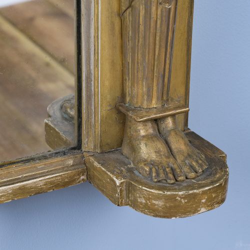 A rectangular Regency giltwood overmantel mirror framed with Egyptian revival term pilasters, sculpted head capitals, and an architectural molded cornice. View VII