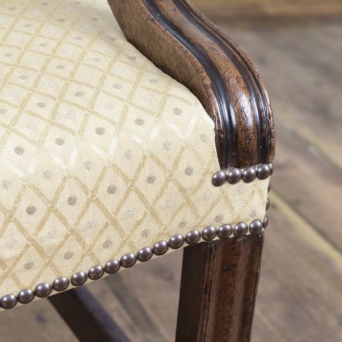 A George III mahogany Gainsborough armchair featuring patterned cream upholstery, brass tack trim, carved serpentine arm supports, and straight legs with brass castors. View XI