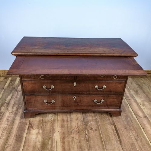 A George II Cuban mahogany chest featuring brass drop handles, keyhole escutcheons, a top brushing slide, two short drawers, two long drawers, and bracket feet. View X