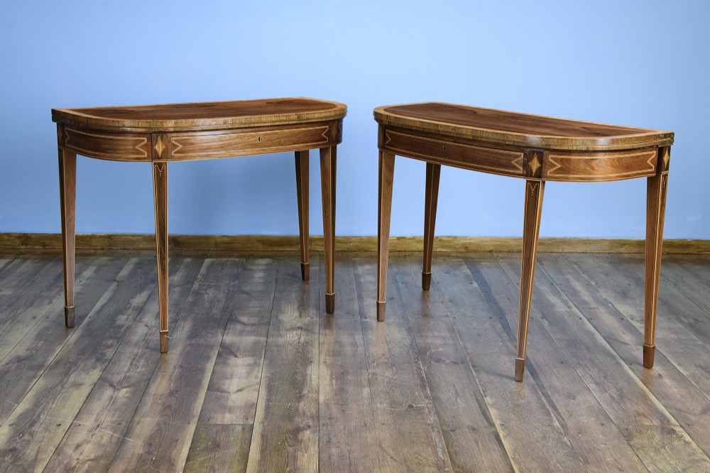 A pair of late 18th-century demi-lune card tables crafted from dark rosewood with contrasting satinwood crossbanding and tapered legs. View II