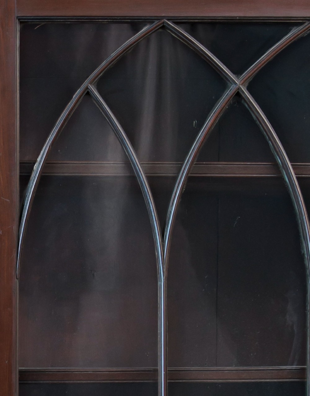 An 18th-century George III mahogany library bookcase featuring two upper glazed doors with Gothic astragal bars and two lower panelled cupboard doors. View II