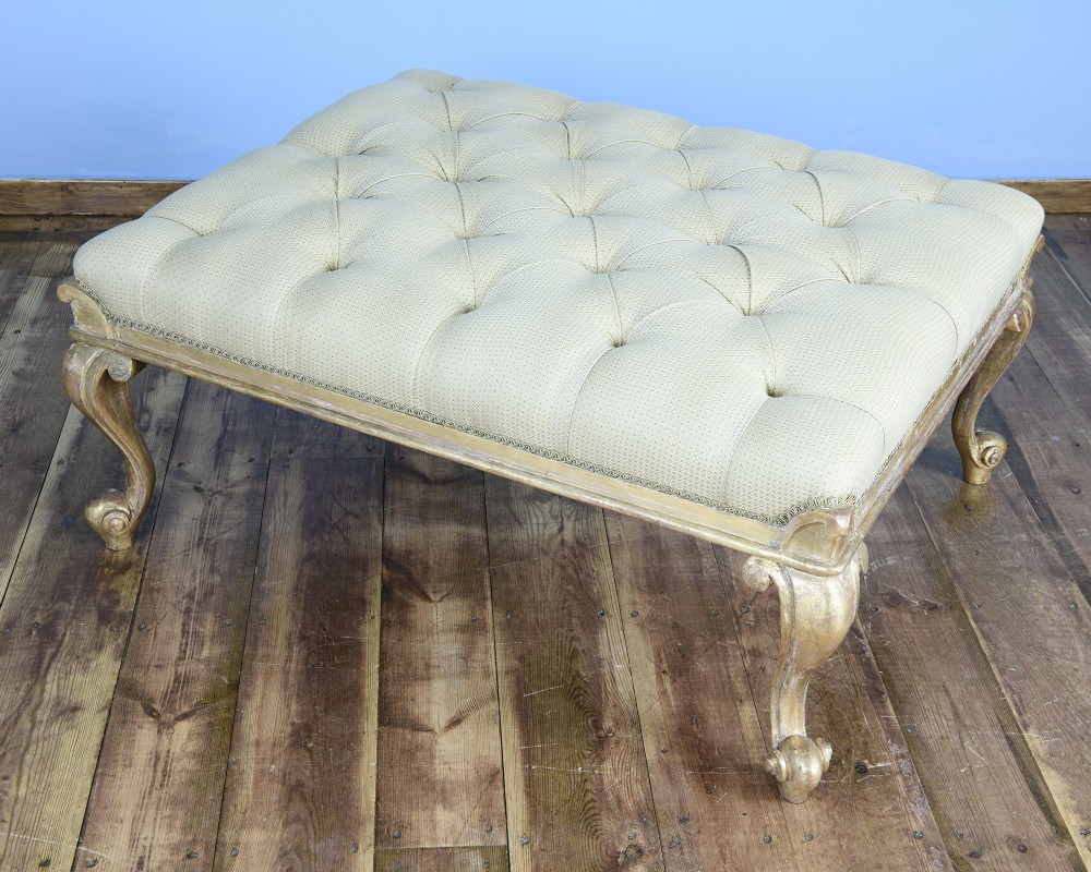 A large William IV style footstool with button-tufted cream upholstery and carved parcel gilt cabriole legs. View III