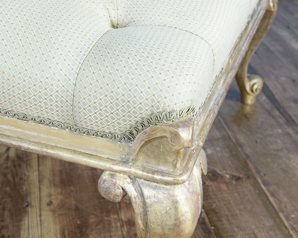 A large William IV style footstool with button-tufted cream upholstery and carved parcel gilt cabriole legs. View IV