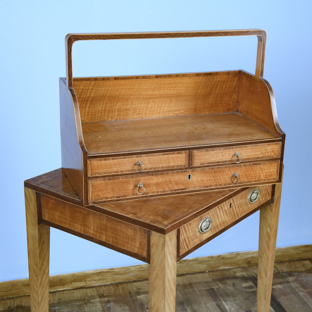 An 18th-century Georgian satinwood cheveret writing table featuring slender square tapered legs, brass ring pulls, and a upper cabinet with an integrated handle. View IV