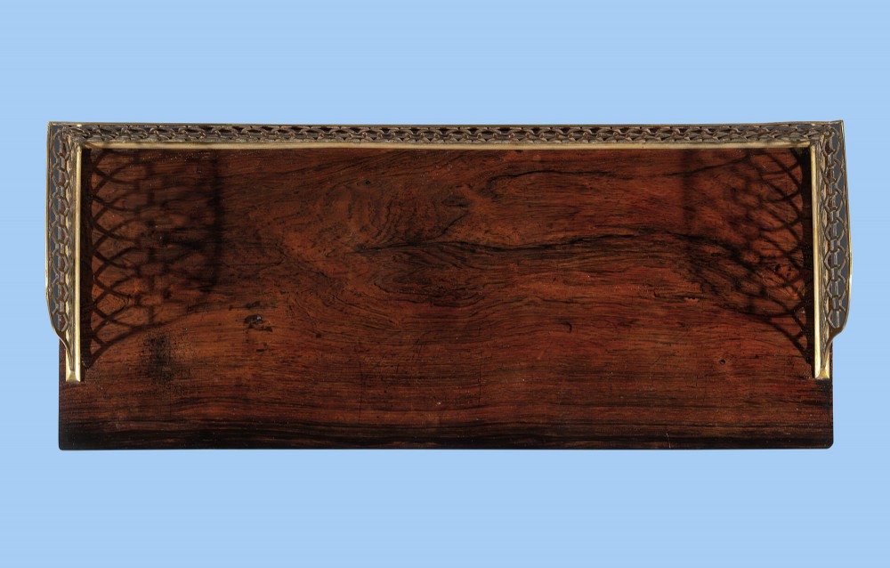 A Regency period rosewood side cabinet featuring brass floral inlay, a brass pierced gallery rail, and a single door with a pleated fabric panel. View III
