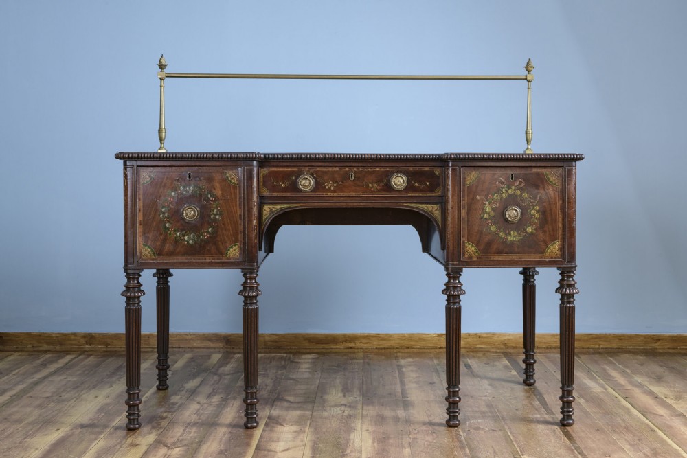 An 18th-century Georgian mahogany sideboard featuring hand-painted floral wreaths, fluted turned legs, and an elevated brass curtain rail. View II