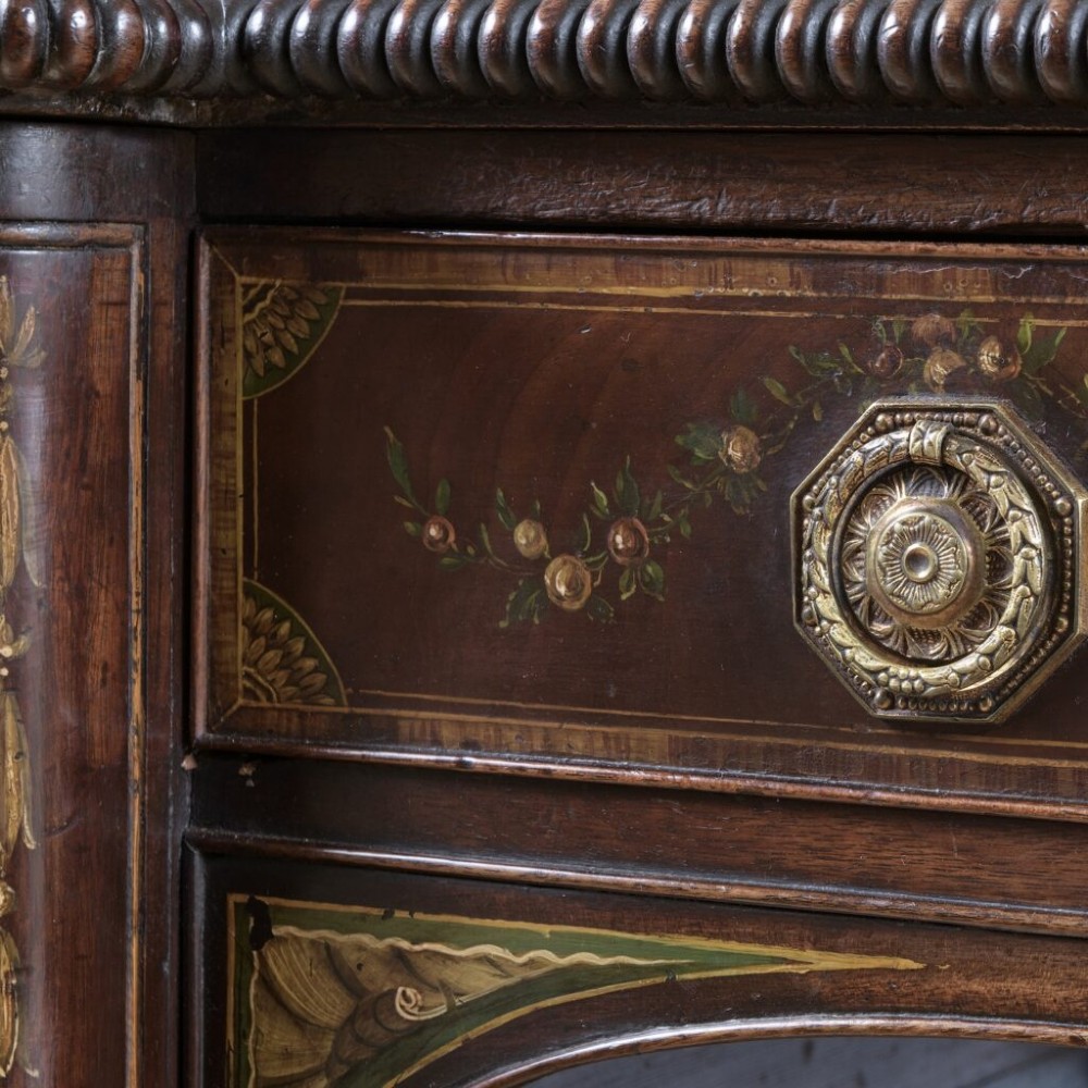 An 18th-century Georgian mahogany sideboard featuring hand-painted floral wreaths, fluted turned legs, and an elevated brass curtain rail. View VI