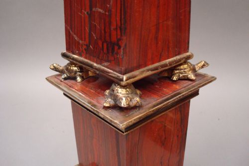fig 1. A pair of red marble obelisks featuring gilt metal collars and stepped bases.