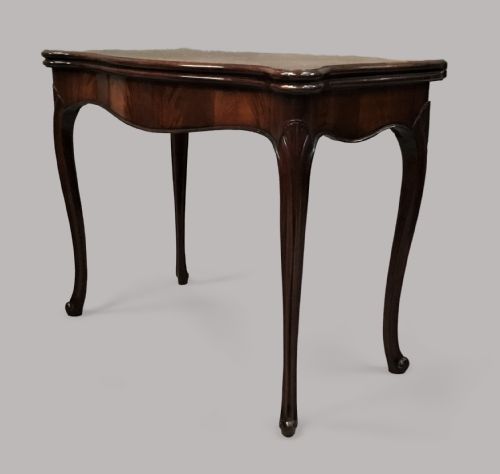 fig 1. A George III mahogany Hepplewhite card table featuring a serpentine apron, shaped cabriole legs, and a hinged fold-over top.