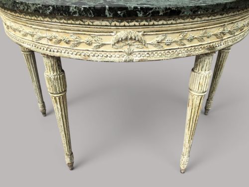 fig 1. An 18th-century Italian Neoclassical demilune console table featuring an off-white painted timber frame with fluted tapered legs and a dark green marble top.