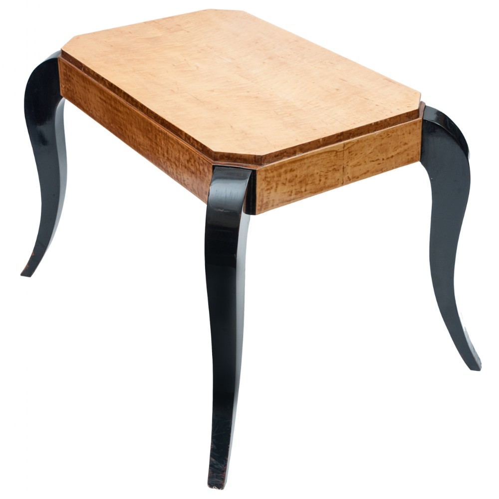 An Art Deco occasional table featuring a canted rectangular birds eye maple top supported by four swooping ebonised black legs.