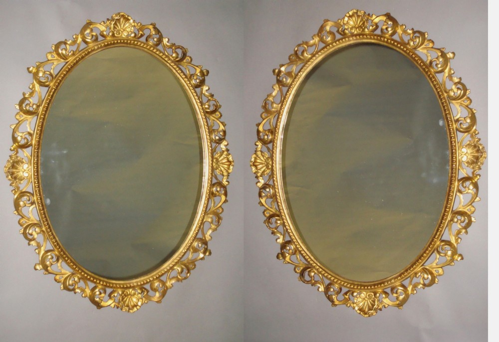 A mid C19th pair of Florentine carved giltwood wall mirrors