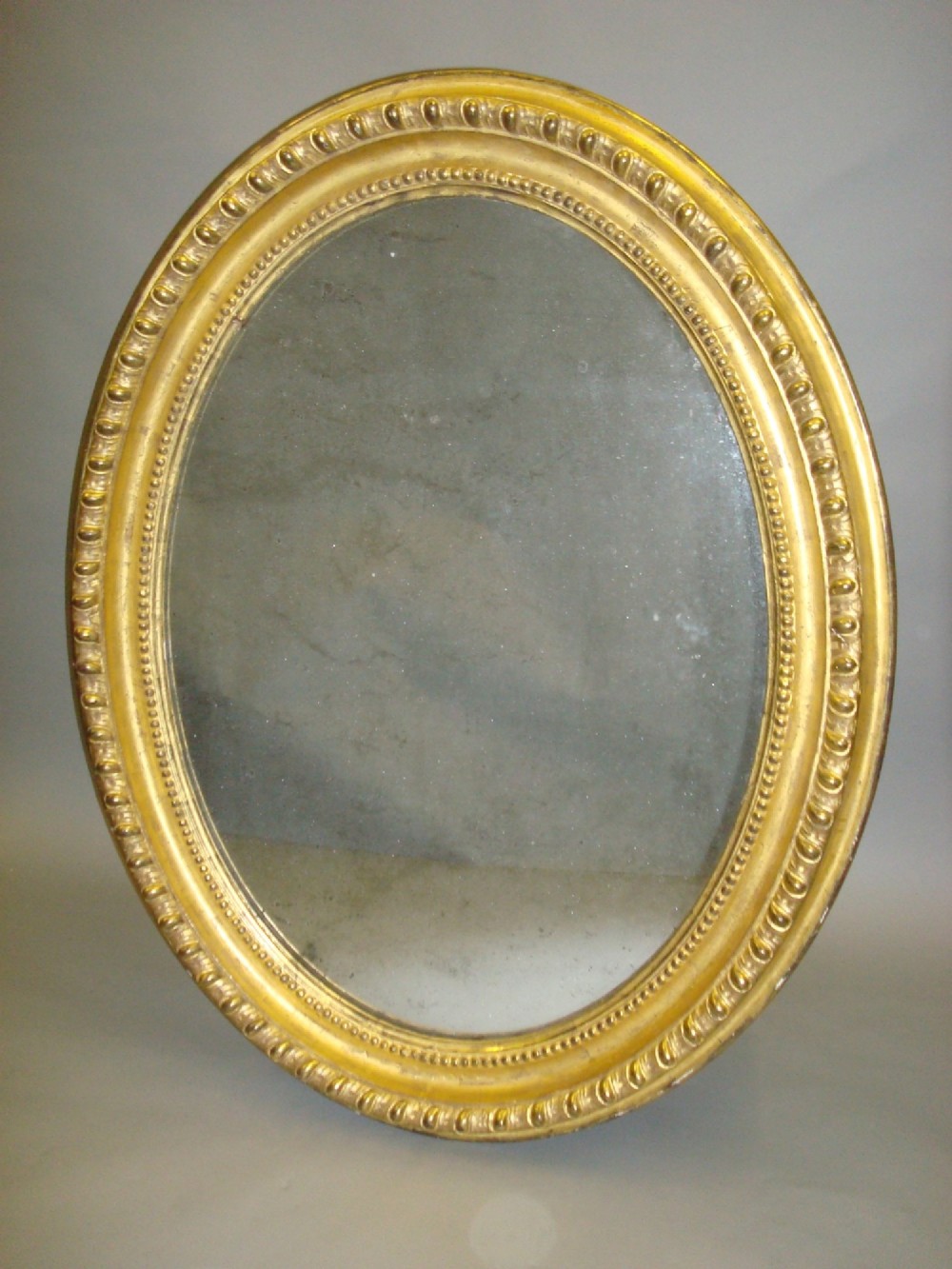 An early C19th giltwood oval wall mirror