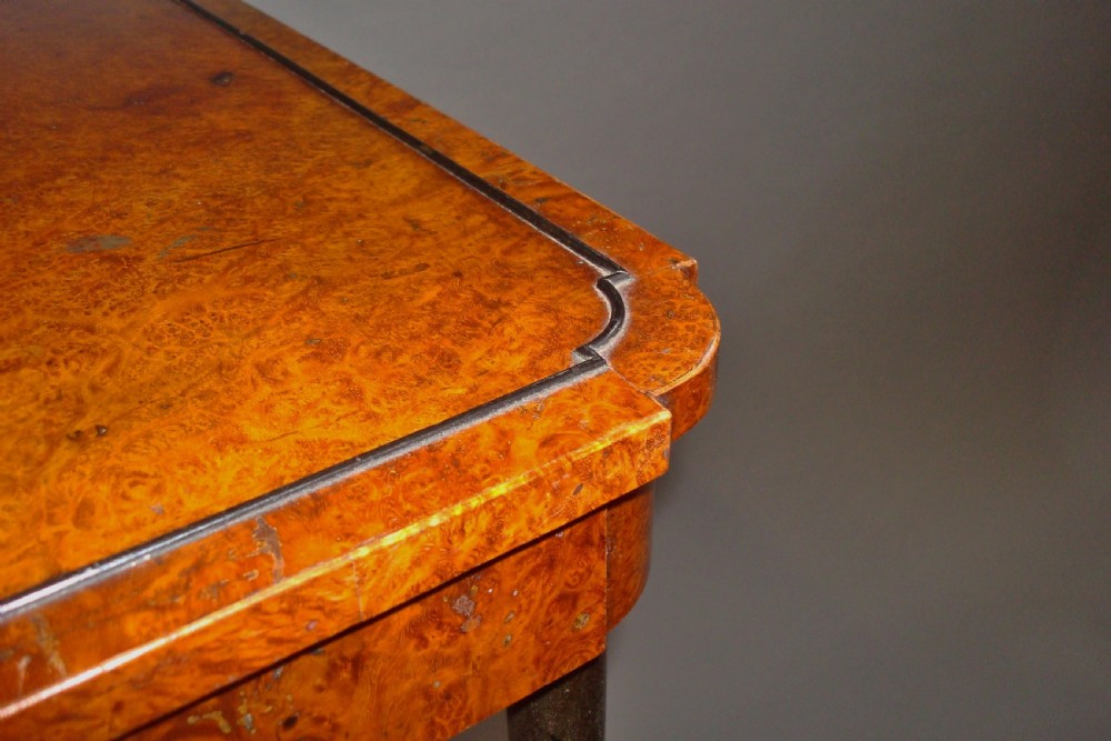 A pair of tall Regency occasional tables featuring square amboyna tops, ebonised turned legs with gilt accents, and concave undertiers. View VII