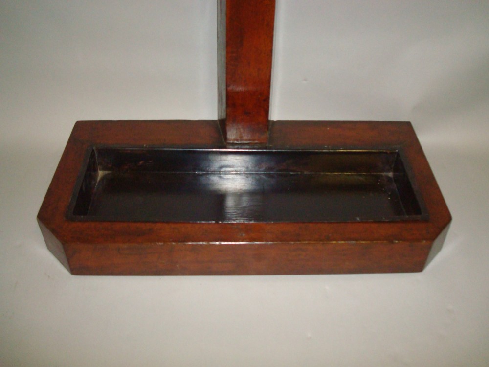 A nineteenth-century dark oak hall stand featuring multiple mounted polished cow horns for coat hooks and an integrated rectangular drip tray at the base. View VII