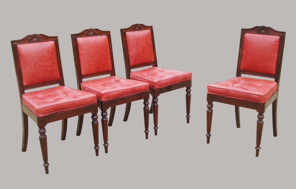 A set of four Regency mahogany side chairs featuring carved crest rails, red leather buttoned upholstery, and turned front legs. View II