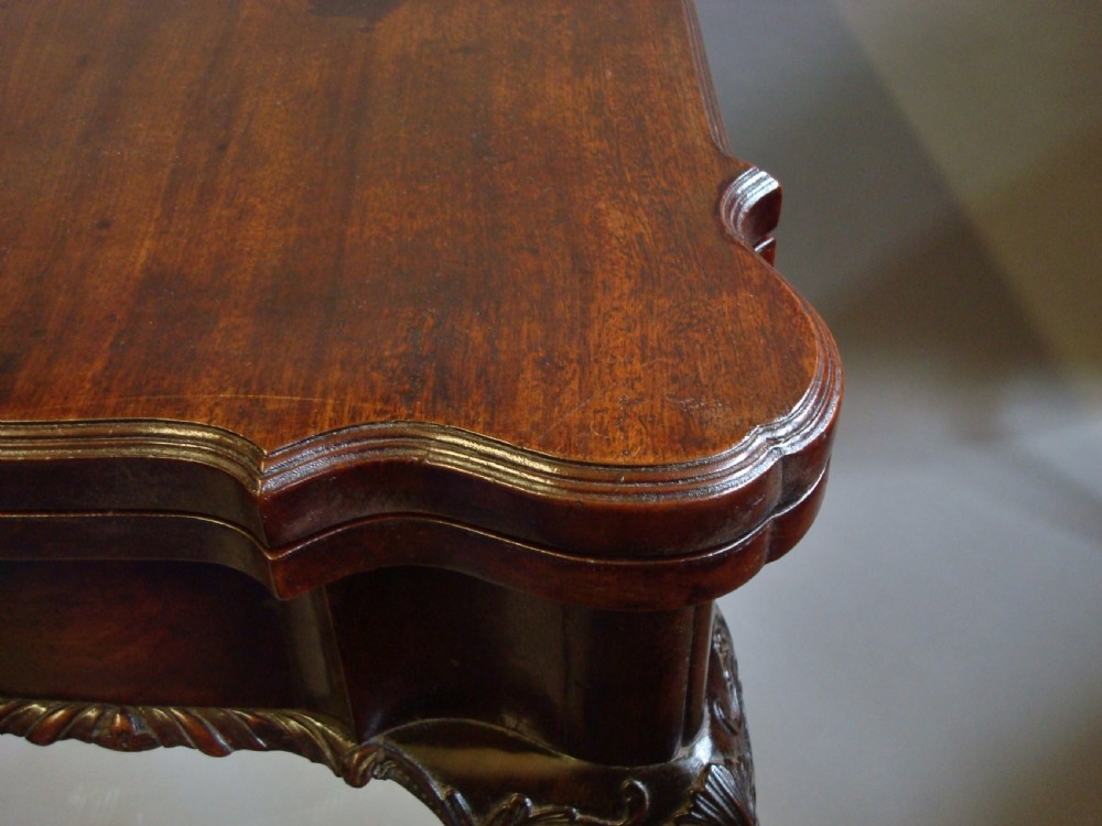 A George III mahogany card table with a fold-over top, a single frieze drawer, carved cabriole legs, and claw and ball feet. View X