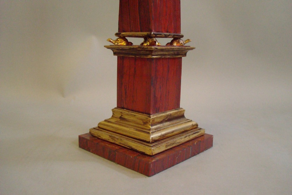 A pair of red marble obelisks featuring gilt metal collars and stepped bases. View VIII