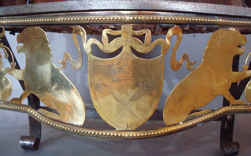 A 19th-century Neoclassical style fire grate constructed from black iron with a scroll-ended basket, flanked by polished brass columns and an ornate pierced brass apron featuring lion motifs. View IV