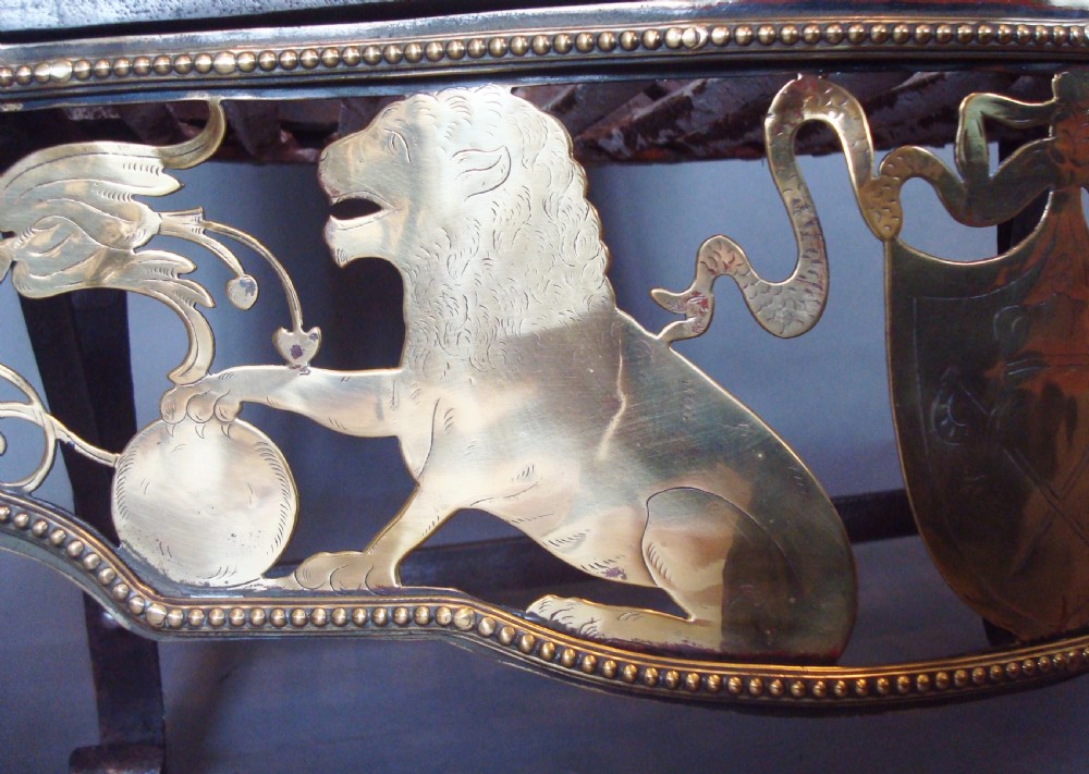 A 19th-century Neoclassical style fire grate constructed from black iron with a scroll-ended basket, flanked by polished brass columns and an ornate pierced brass apron featuring lion motifs. View VI