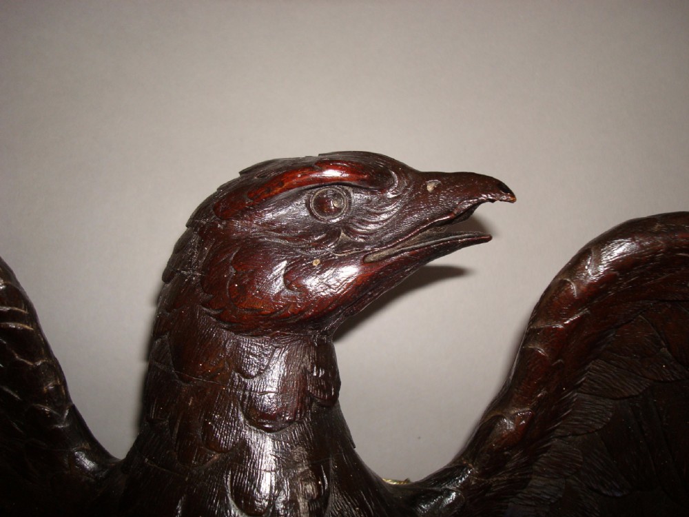 A 19th-century dark carved wood coat rack featuring an eagle with outstretched wings perched on a rustic branch with integral hanging pegs. View II