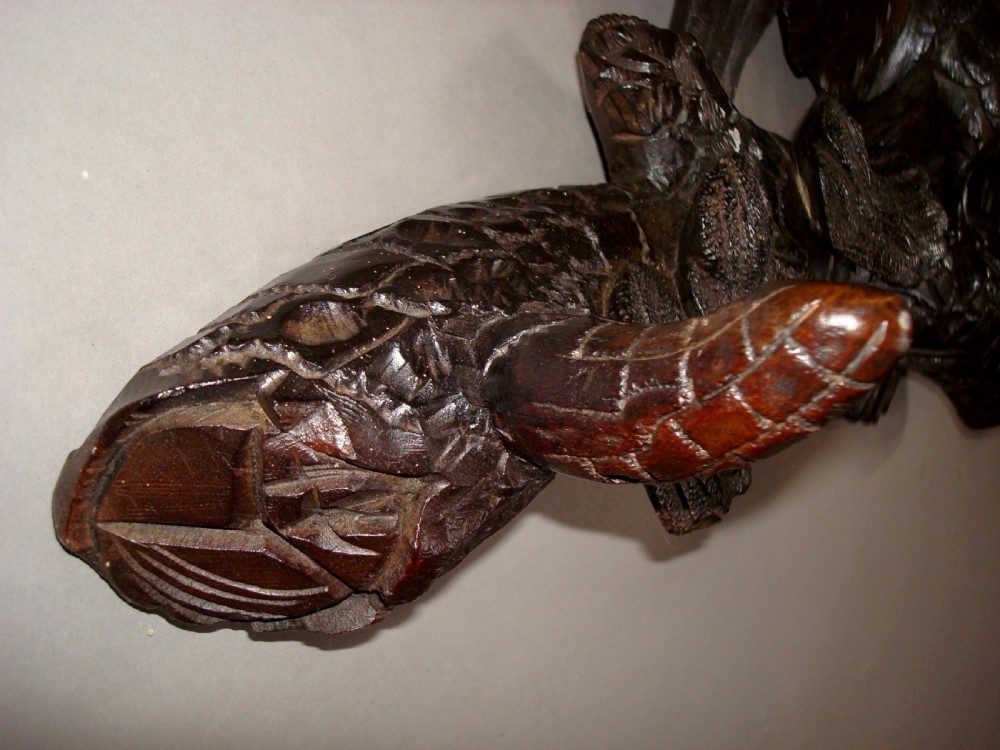 A 19th-century dark carved wood coat rack featuring an eagle with outstretched wings perched on a rustic branch with integral hanging pegs. View V
