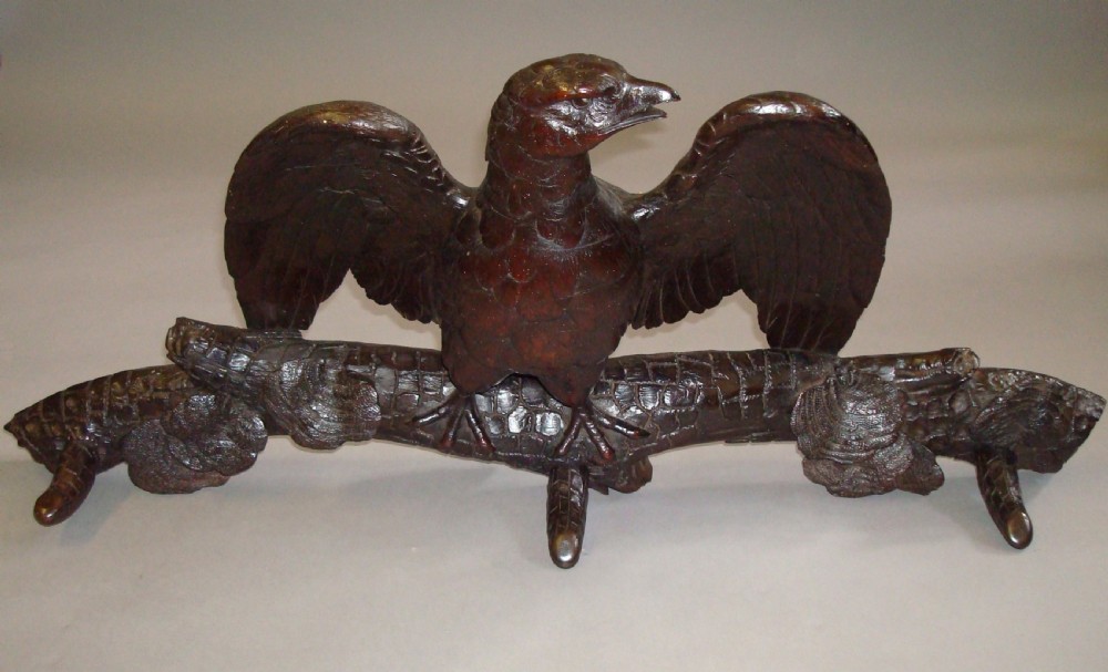 A 19th-century dark carved wood coat rack featuring an eagle with outstretched wings perched on a rustic branch with integral hanging pegs. View VIII