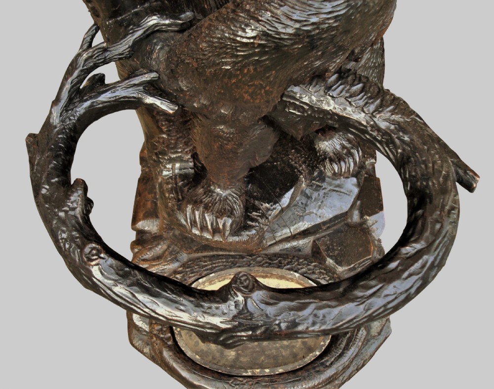 A 19th-century hand-carved dark wood Black Forest hall stand depicting a standing bear holding a naturalistic branch ring above a carved drip tray base. View IV