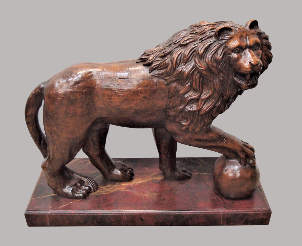A pair of nineteenth-century carved wooden Medici lions depicted standing with one paw resting on a sphere, mounted on reddish marbled rectangular bases. View XIII