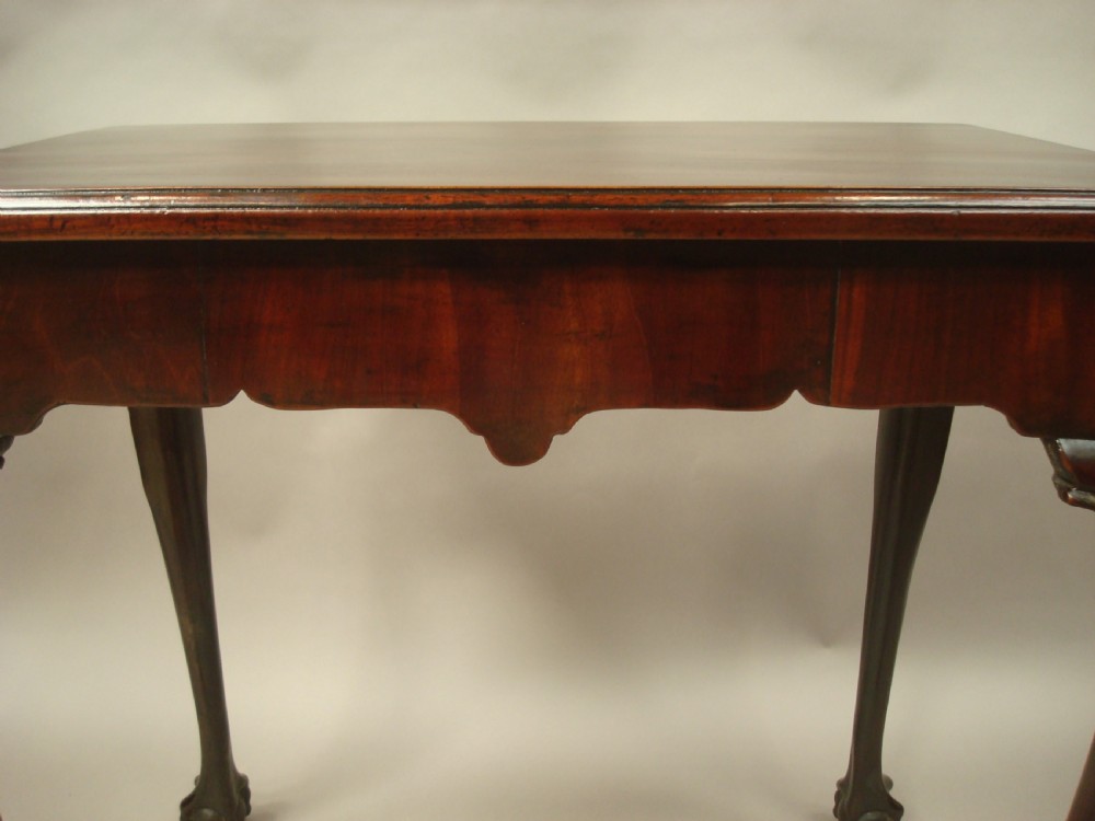 A George II mahogany silver table featuring carved cabriole legs ending in ball and claw feet, shell-carved knees, and a shaped apron. View IV