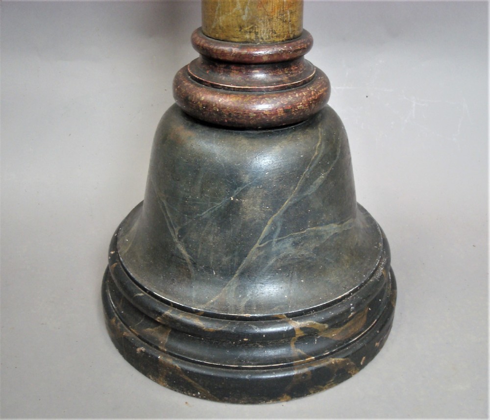 A tall Regency pine torchere pedestal featuring a faux marble painted shaft, carved acanthus leaf capital, and a dark stepped circular base. View XIV