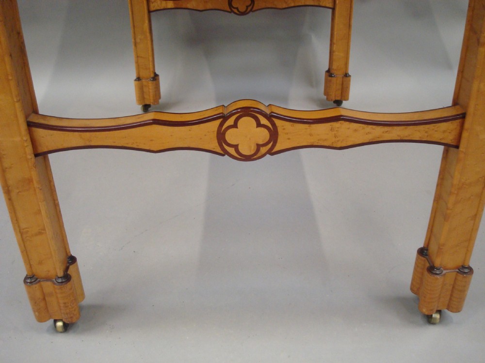 A nineteenth-century French birds eye maple sofa table featuring drop-leaf ends, twin drawers, Gothic Revival spandrels, and a low stretcher with trefoil inlay. View VII