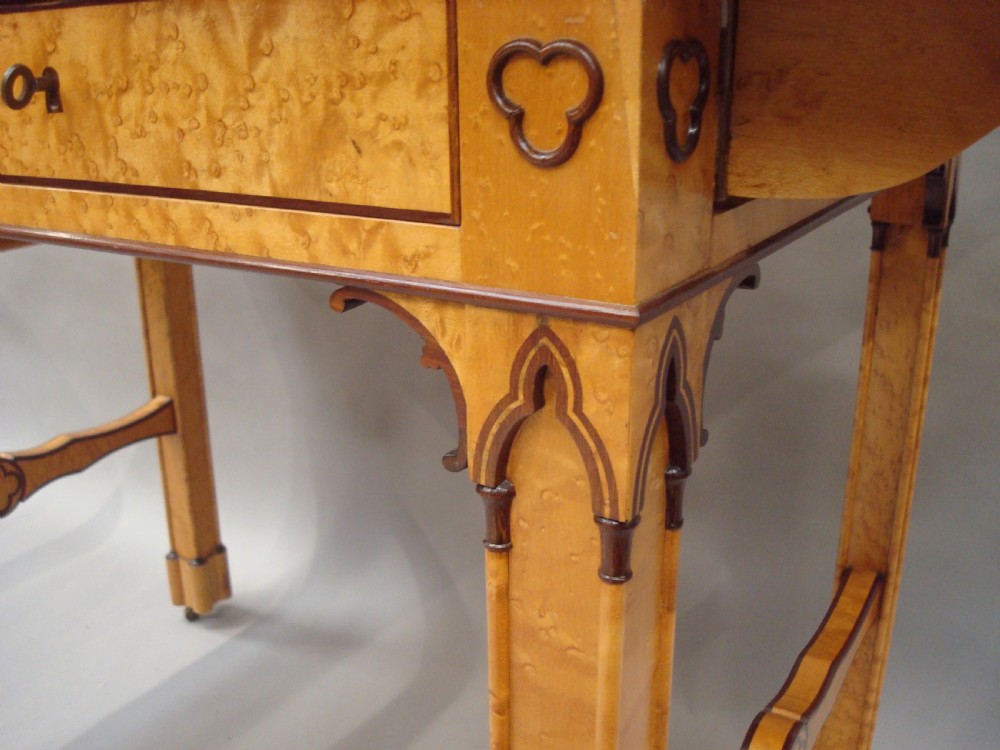 A nineteenth-century French birds eye maple sofa table featuring drop-leaf ends, twin drawers, Gothic Revival spandrels, and a low stretcher with trefoil inlay. View XI